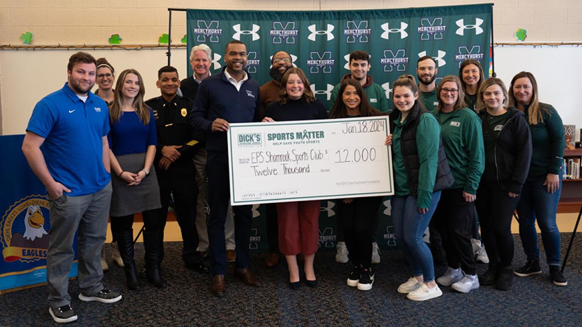 Group photo of Mercyhurst University's new intramural partners Erire Public Schools holding a check for $12,000 Sports Matter grant, provided by Dick's Sporting Goods Foundation