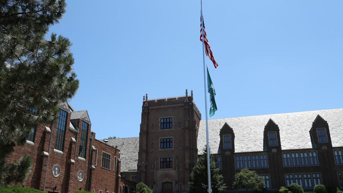 Campus shot of Old Main and American and Mercyhurst flag