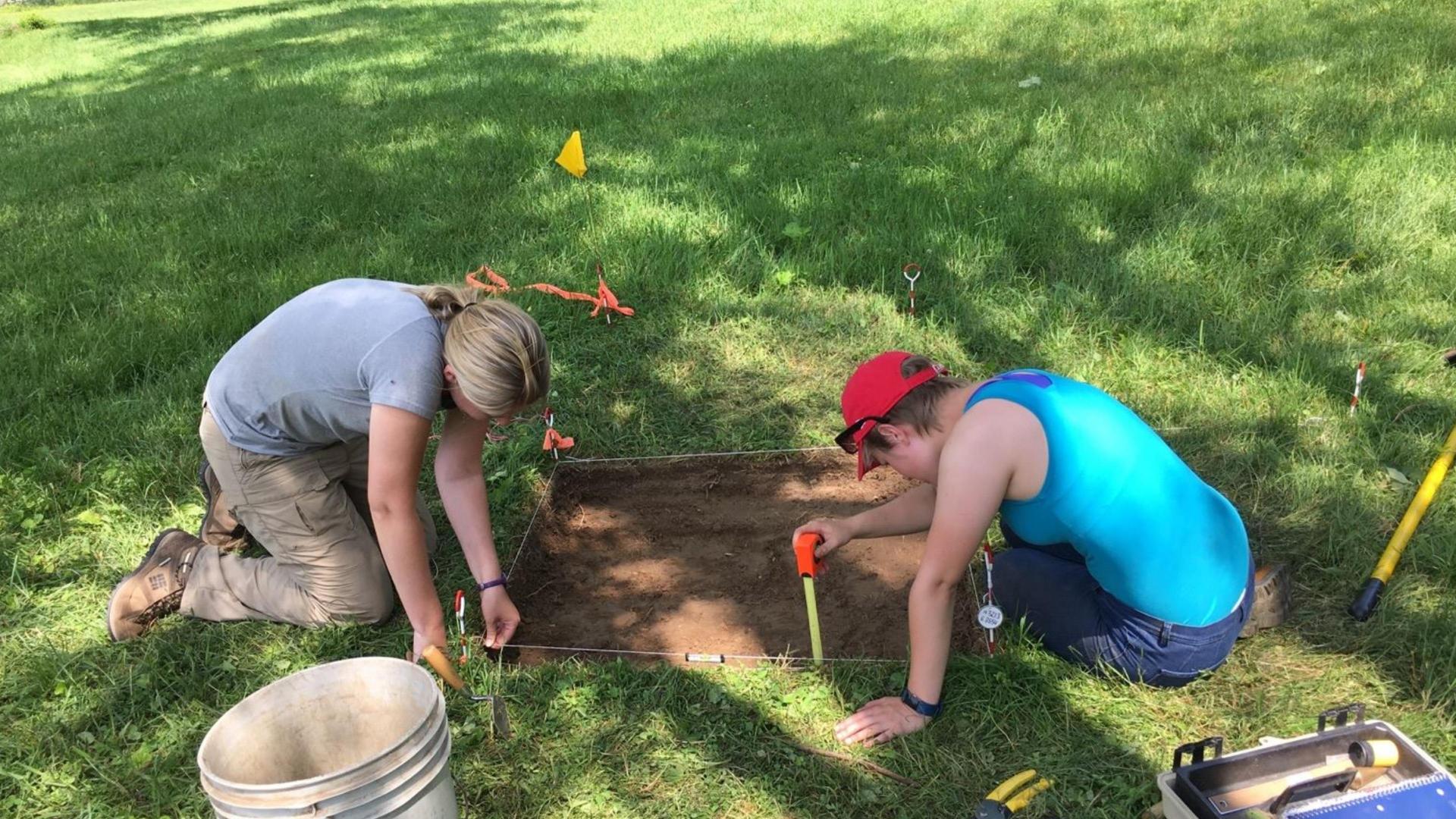 male and female student working at a dig sight