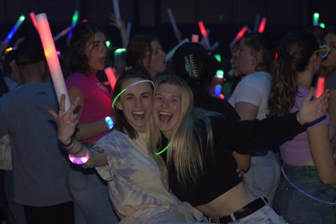 two girls in a crowd with light-up sticks at SpringFest