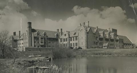Black and white rear view of Egan Hall Administration and Chapel with Lake William and Island in 1935