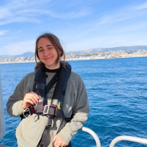 Image of Maya Bauer, posing for a photo in front of a body of water