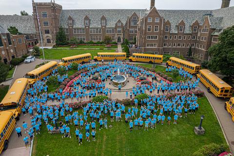 Students and Day of Service buses in front of Old Main