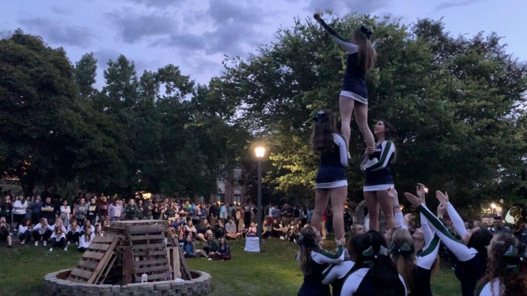 Cheerleaders forming a pyramid before lighting the homecoming bonfire