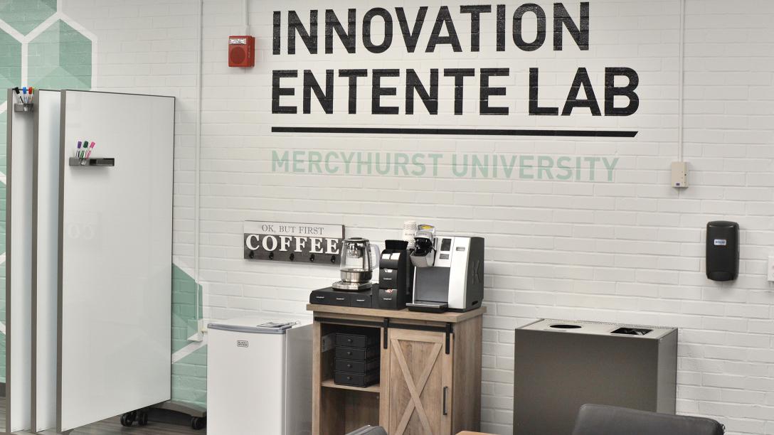 Mercyhurst's Innovation Entente lab sign, workspaces, and coffee bar