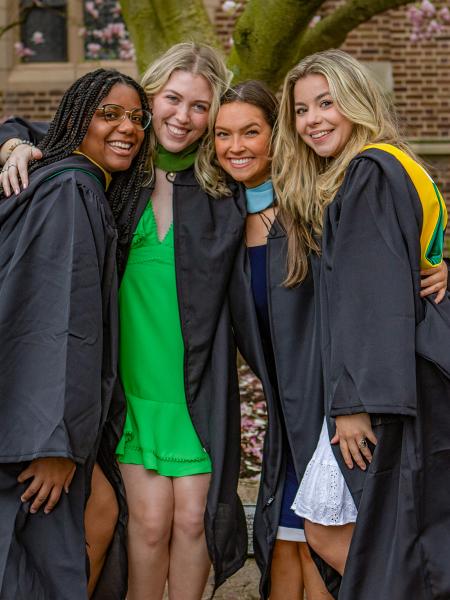 Graduates at the magnolia tree outside of Old Main